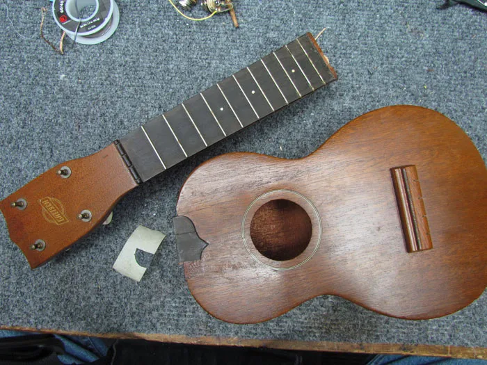 Disassembled ukulele undergoing structural repair